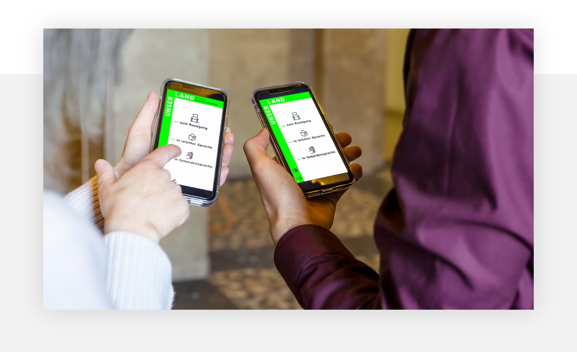 Zwei Personen halten jeweils ein Smartphone mit aktivem Startscreen der Mediaguide Web App. Eine Personen deutet auf den Screen ihres Smartphones.